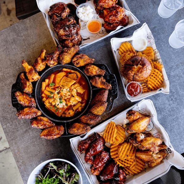 Goobne Chicken's Korean fried chicken, waffle fries, and tteokbokki in a cast iron pot.