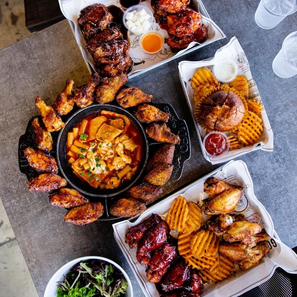 Goobne Chicken's fried chicken platters with waffle fries, sauces, and a tteokbokki hot pot.